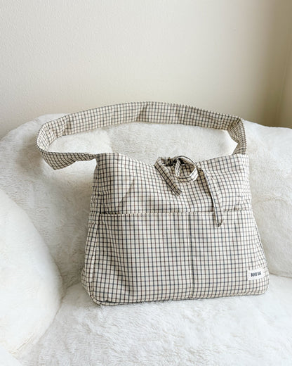 Plaid-patterned bag on a white surface with a neutral background