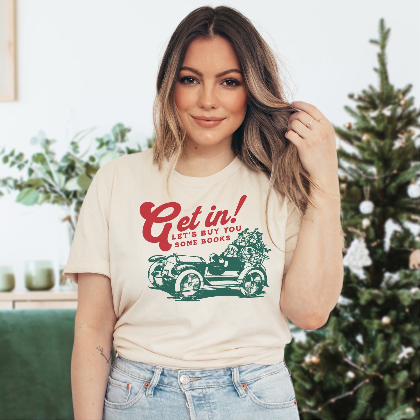 Woman wearing a cream t-shirt with 'Get in! Let's buy you some books' vintage car graphic