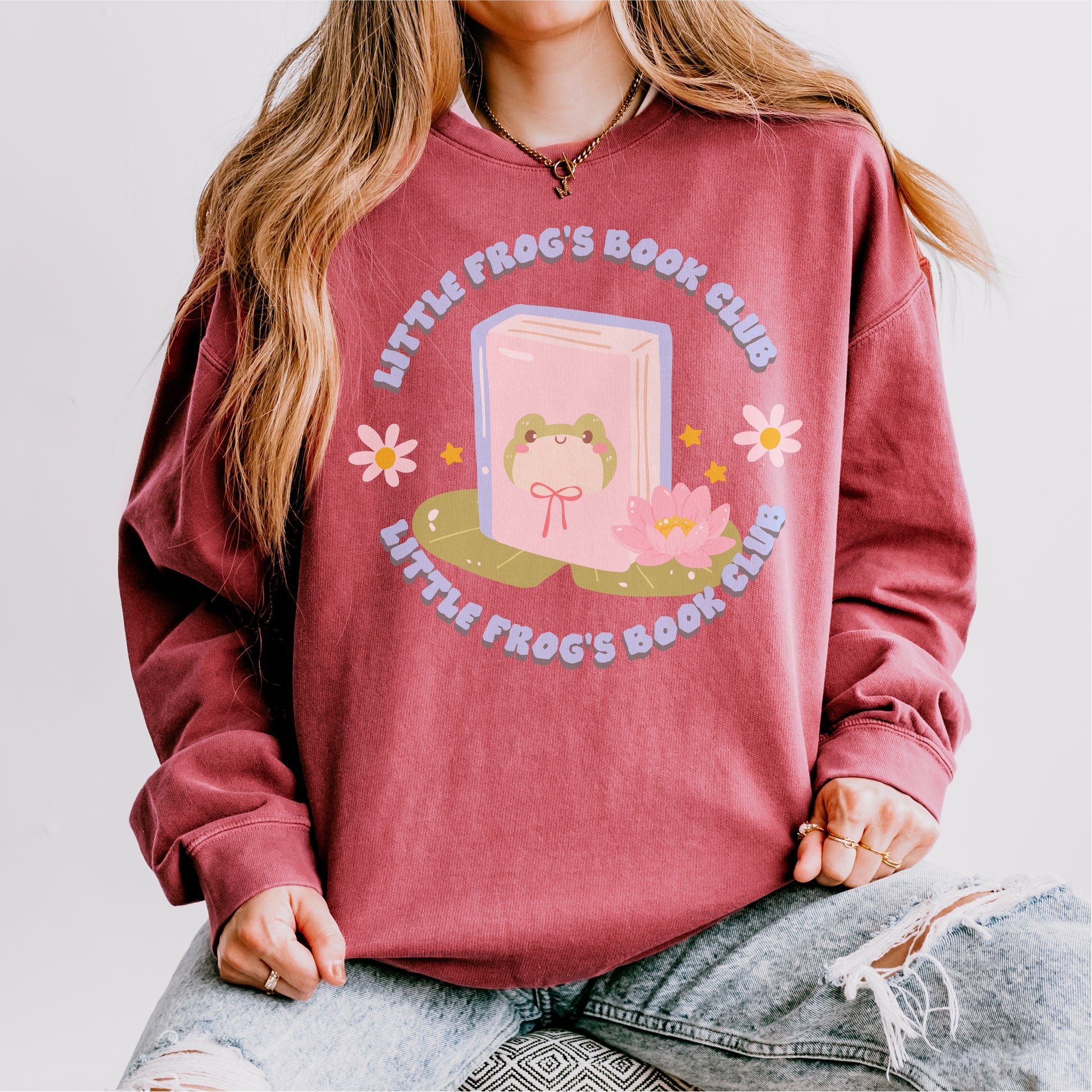 Burgundy sweatshirt with frog and book graphic, floral accents, and 'Little Frog's Book Club' text