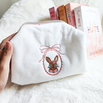 Little Rabbit and Her Book Zippered Pouch | Bookish Makeup & Reading Accessories Bag - The Bean Workshop - book girlie, bookish gift, bookish pouch, bow, coquette, coquette aesthetic, embroidered pouch, gift for book lovers, kindle bag, makeup bag, quilted pouch, rabbit book bag, reading accessories, reading accessories bag, zipper pouch