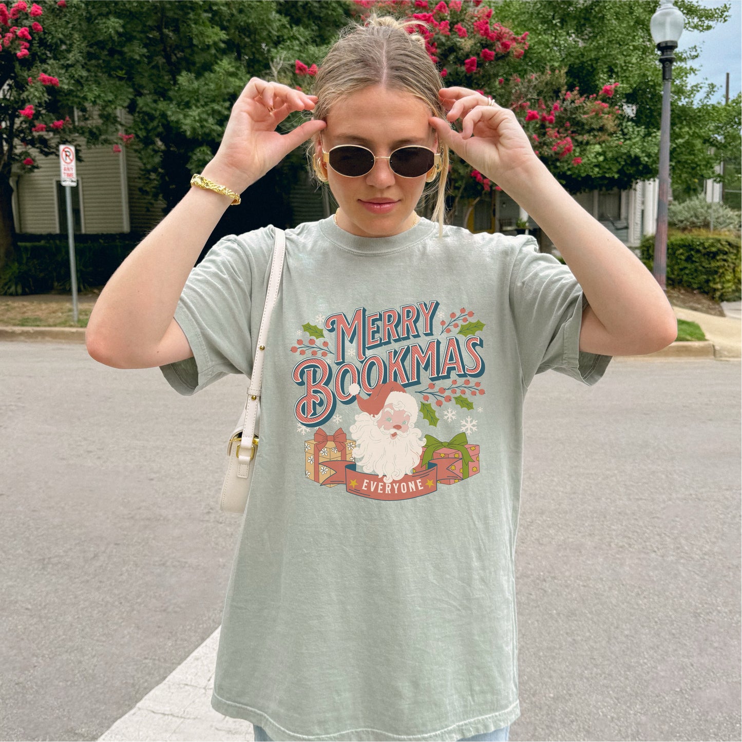 Woman wearing Merry Bookmas t-shirt with festive Santa and book design outdoors