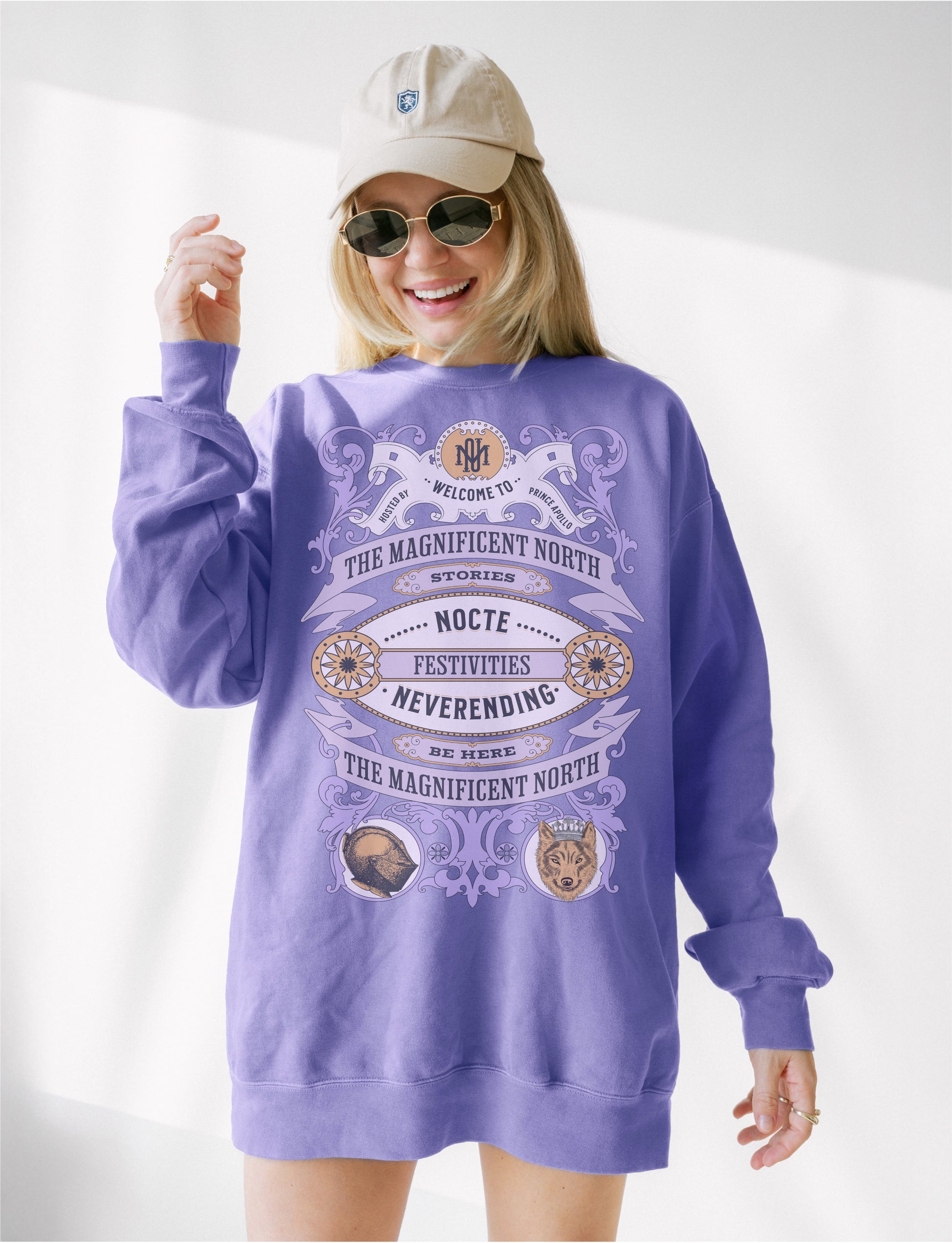 Woman wearing a light purple bookish sweatshirt with ornate literary design and animal illustrations.
