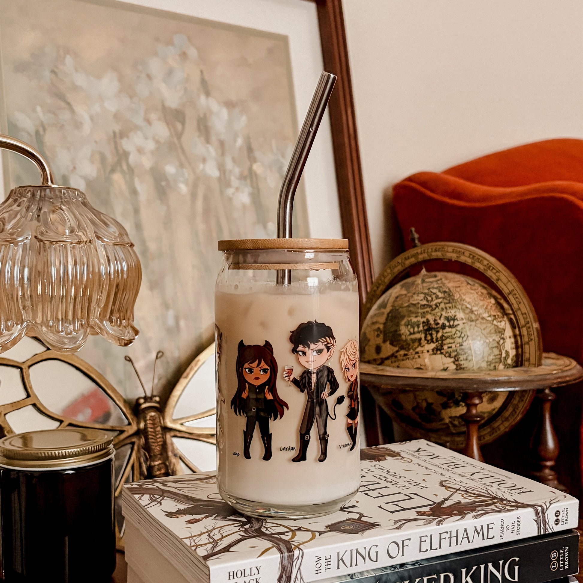 Glass cup with bookish character art, iced coffee, straw, on fantasy books stack in cozy reading nook