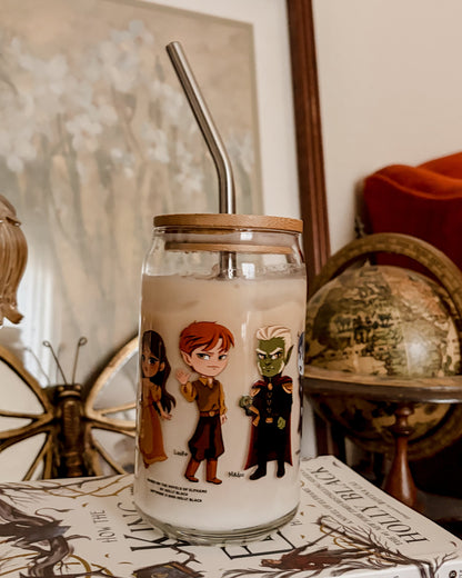 Glass cup with book character illustrations, bamboo lid, metal straw, on a fantasy novel