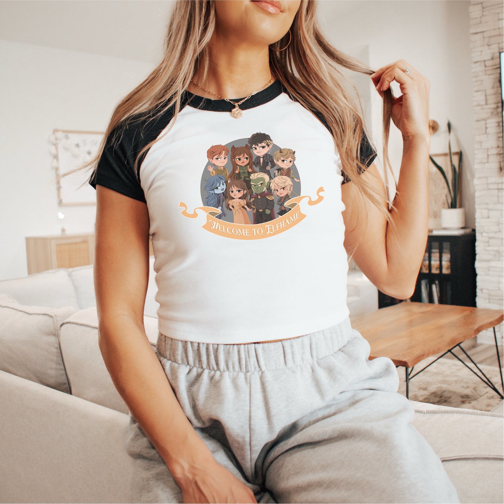 Woman wearing a crop tee with chibi fantasy characters and 'Welcome to Elfhame' design