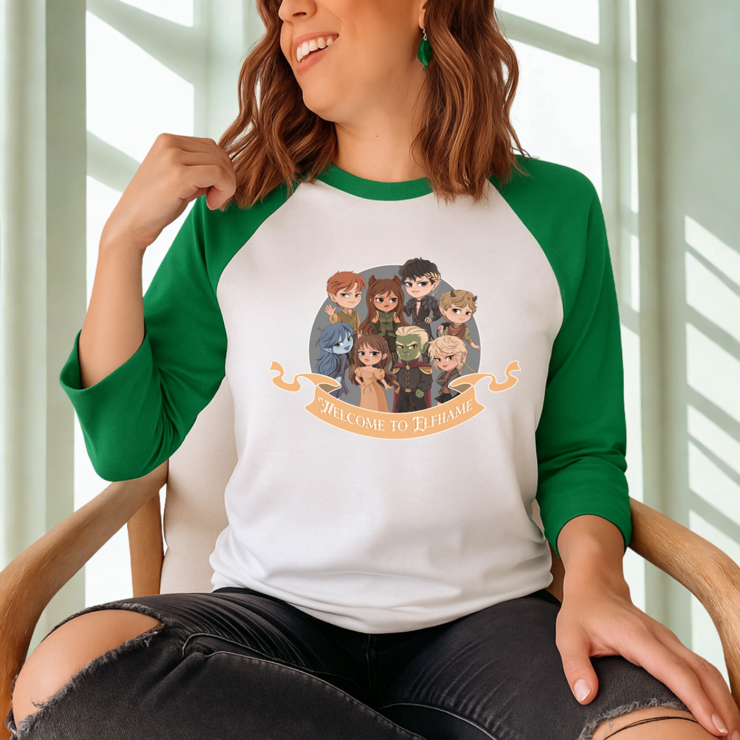Woman wearing green and white raglan tee with chibi fantasy characters and 'Welcome to Elfhame' banner