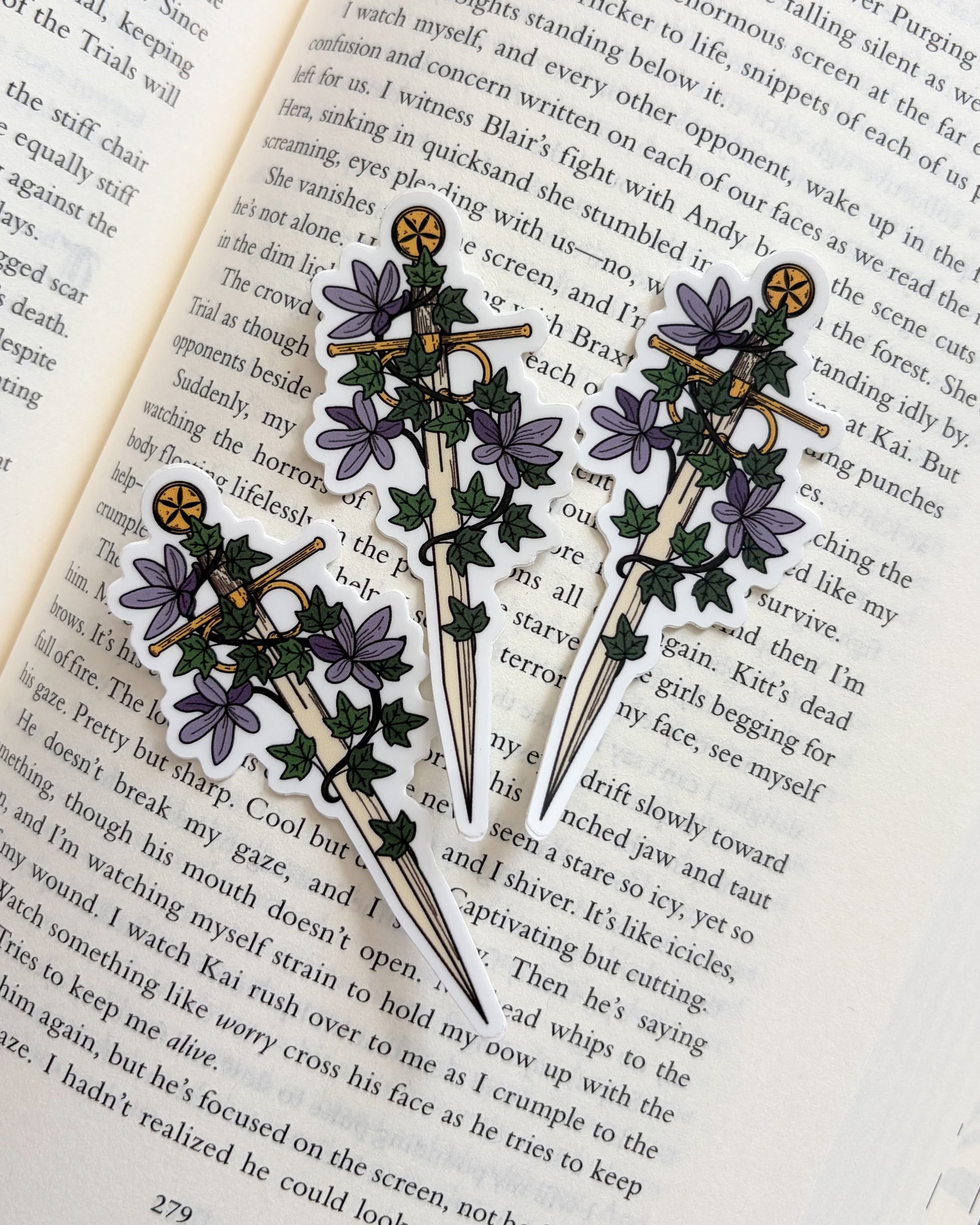 Three decorative brooches with floral designs on an open book