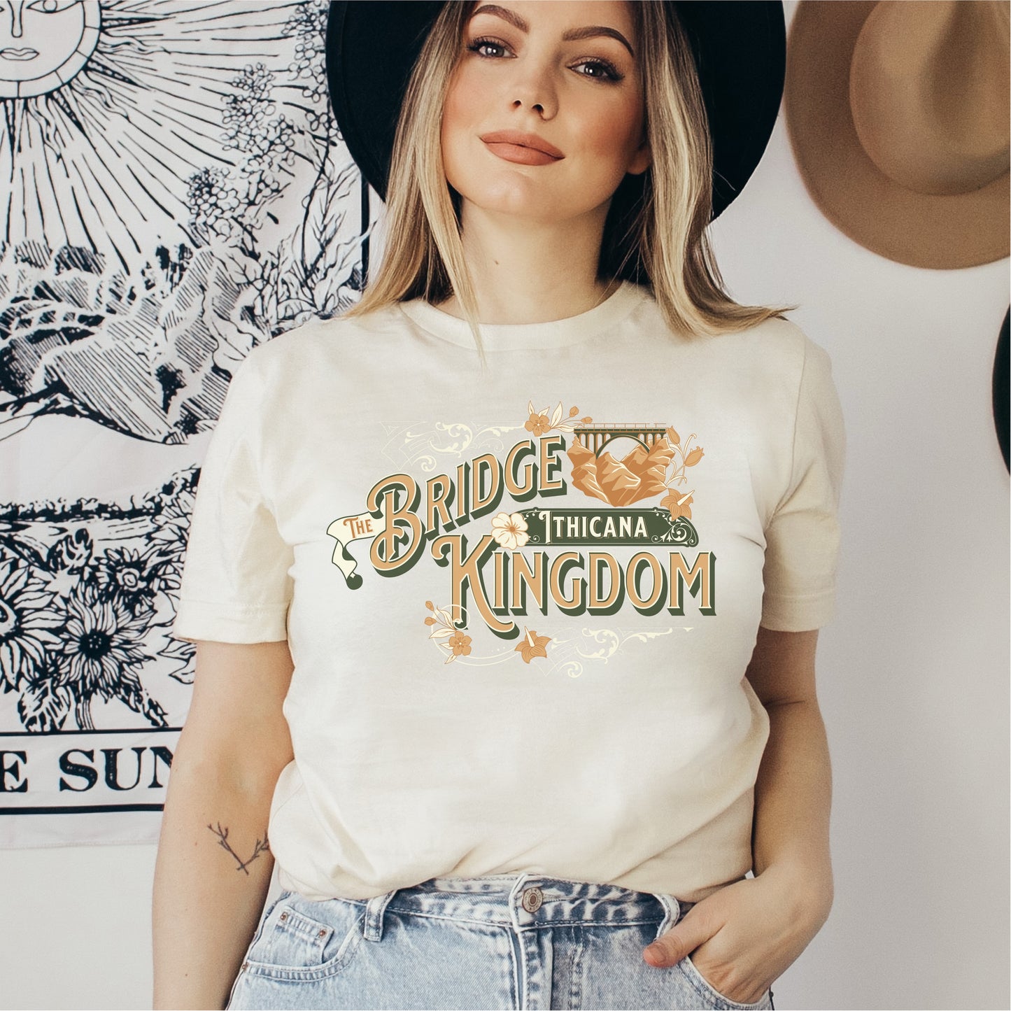 Woman wearing cream The Bridge Kingdom Thicana graphic bookish t-shirt, casual style