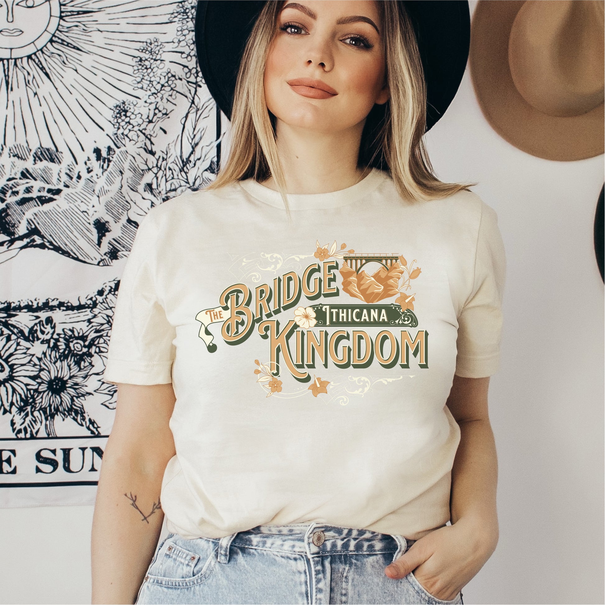 Woman wearing cream The Bridge Kingdom Thicana graphic bookish t-shirt, casual style