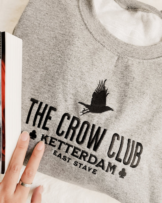 The Crow Club Embroidered Sweatshirt - The Bean Workshop - Book Lover Gift, Bookish Sweatshirt, Cozy Aesthetic, East Stave, Fantasy Book Merch, Grishaverse fan gift, Kaz Brekker, Ketterdam merch for readers, Leigh Bardugo bookish apparel, Literary Logo, Six of Crows cozy sweater, The Crow Club sweatshirt, The Dregs