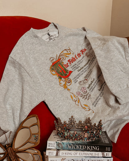 Bookish grey sweatshirt with 'The Folk of the Air' design, floral details, crown, and fantasy books.