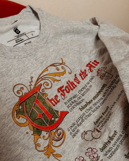 The Folk of the Air sweatshirt with fantasy bookish design, medieval lettering, and illustrated plants