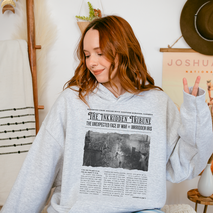 Woman wearing a grey bookish hoodie with newspaper-style war design, cozy reading apparel