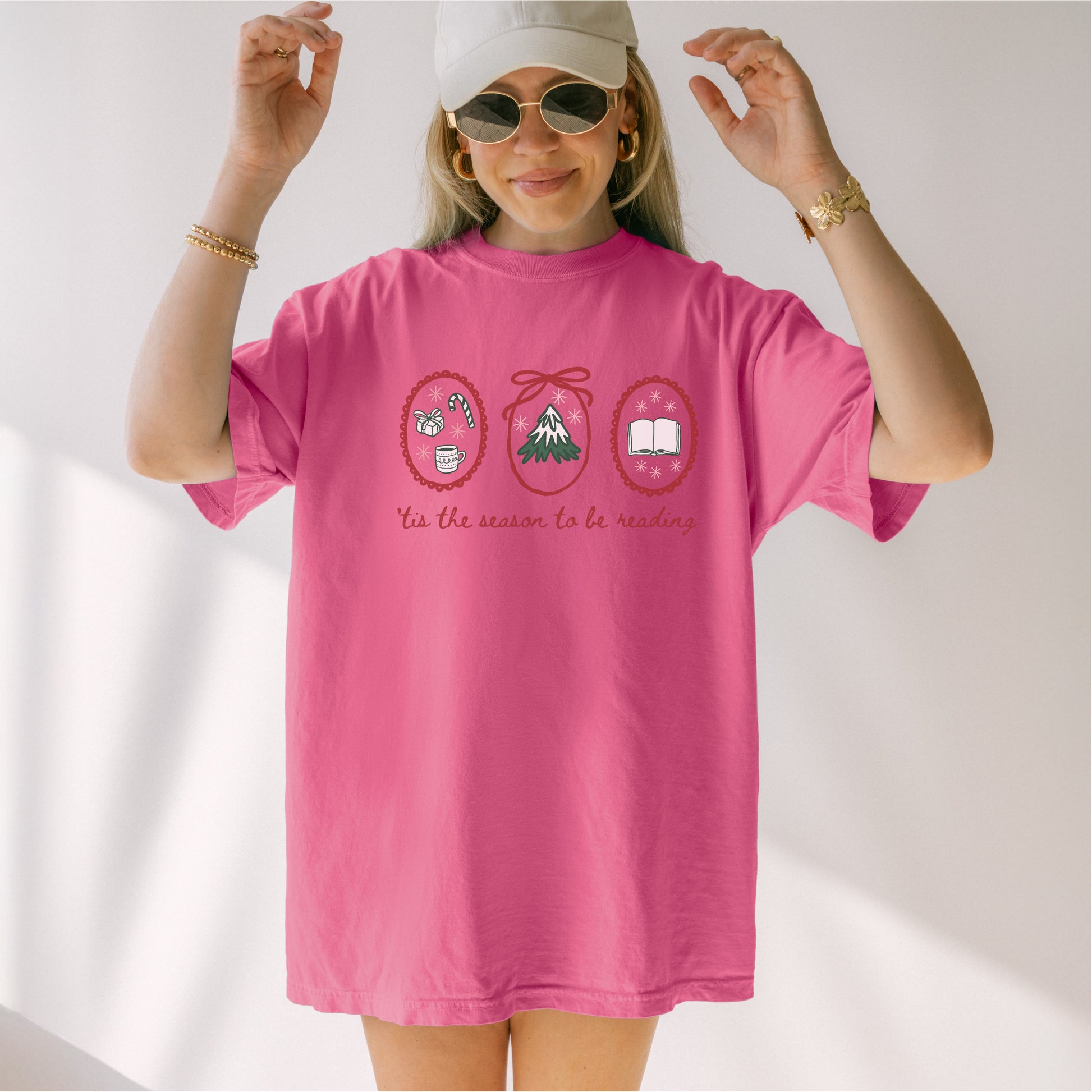 Woman wearing pink Christmas-themed 'tis the season to be reading' bookish t-shirt